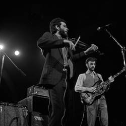 A group of men playing instruments

Description automatically generated
